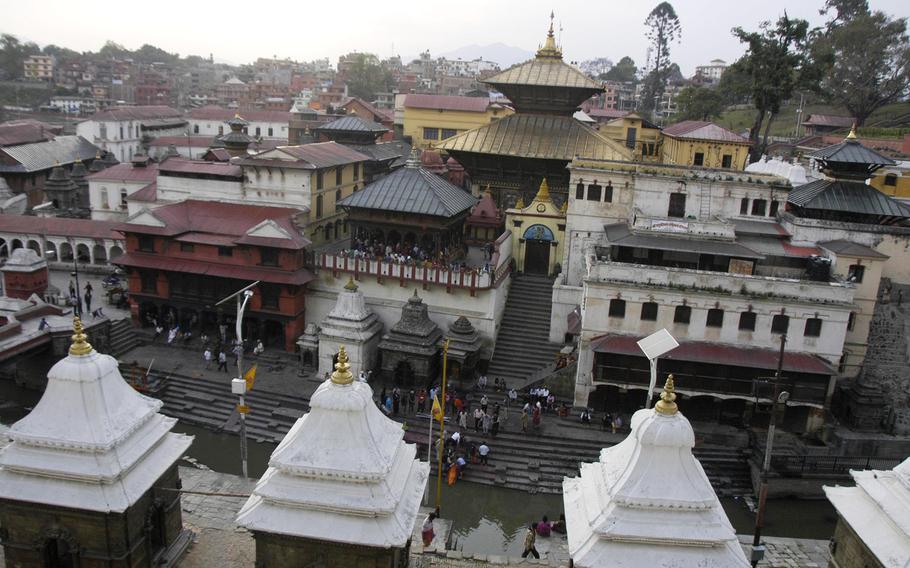 The Pashupattinath Temple to Lord Shiva provides a backdrop to funerals beside the Bagmati River, Nepal. Bodies are burned at the river, following Hindu traditions.