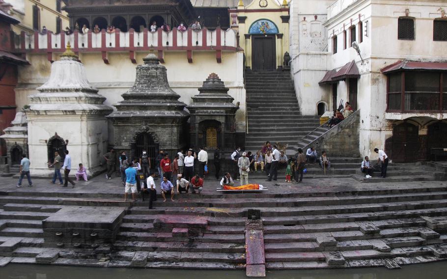 A body is brought to the Bagmati River in Kathmandu, Nepal, for ceremonial washing before cremation.