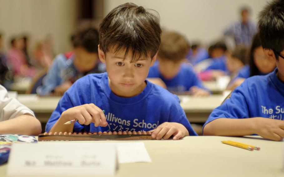 Matthew Burke of The Sullivans School in Yokosuka, Japan, calculates a math problem during the DODEA Pacific Japan District's 33rd annual Soroban Contest at the New Sanno Hotel in Tokyo May 13, 2015. The students were allowed to use only a Japanese soroban, or abacus, to calculate answers.