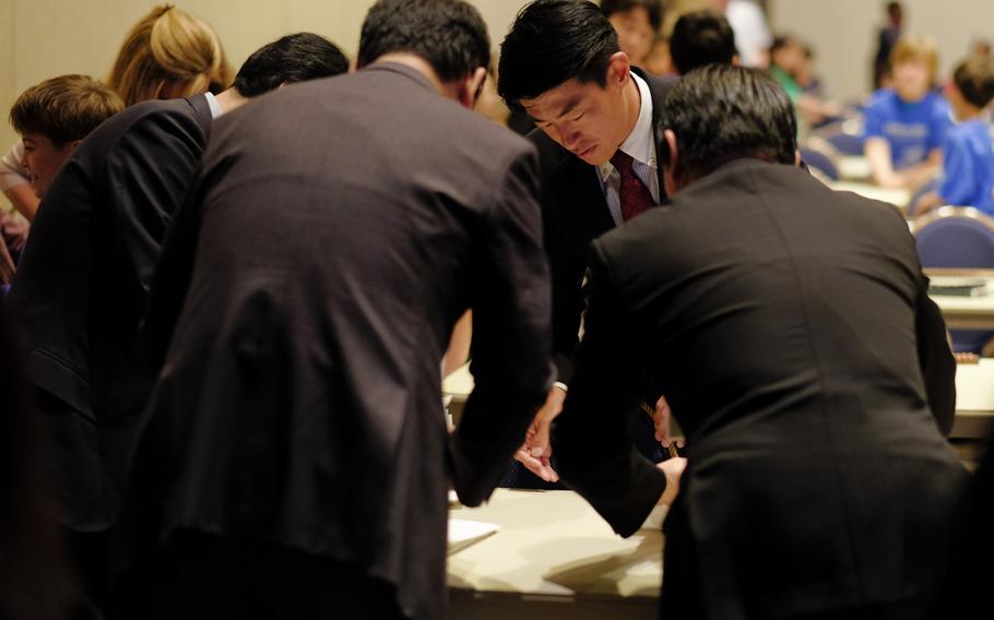 Judges from the Soroban League of Educational Association of Japan review calculations made by DODEA Pacific students during the Japan District's 33rd annual Soroban Contest at the New Sanno Hotel in Tokyo on May 13, 2015.
