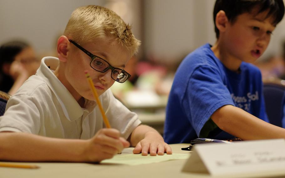 Mason DeLamater writes down his answer to a complex math problem during the DODEA Pacific Japan District's 33rd annual Soroban Contest at the New Sanno Hotel in Tokyo on May 13, 2015. The students were allowed to use only a Japanese soroban, or abacus, to calculate the answers.