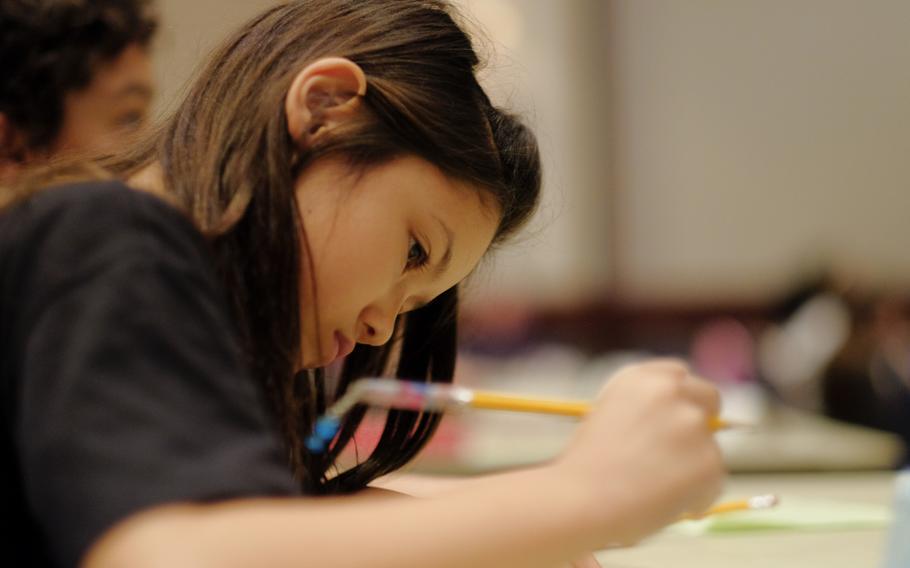 Leah Hamner writes her answer to a math problem during the DODEA Pacific Japan District's 33rd annual Soroban Contest at the New Sanno Hotel in Tokyo on May 13, 2015. Japanese teachers from the various schools at each participating military base offered after-school programs to teach students how to use the abacus, which was the only calculating tool they were allowed to use in the competition.