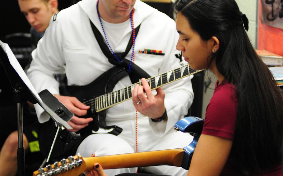 Petty Officer 3rd Class Michael Delorean, a guitarist with the Pacific Fleet Band, plays along with a student at Honokaa Intermediate and High School on he Big Island of Hawaii as part of the Navy's community education and outreach program.