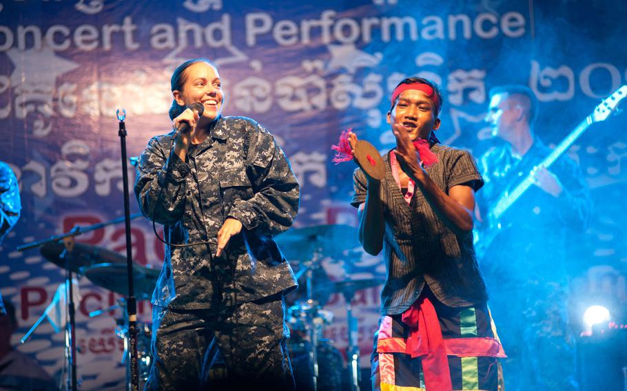 Petty Officer 3rd Class Ann Franek sings with a Cambodian performer at a Pacific Partnership concert at city square in Sihanoukville, Cambodia, in 2014.