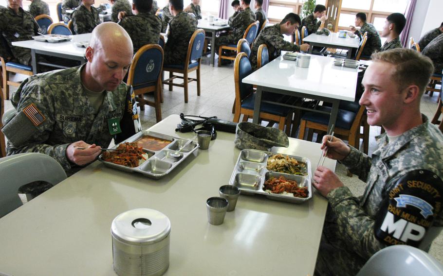 Pfc. Joshua Dixon, right, has lunch with a fellow soldier in April 2015 at the South Korean dining facility on Camp Bonifas, South Korea. The U.S. base a few minutes' drive from the Demilitarized Zone lacks its own dining facility, meaning U.S. troops there must eat traditionally spicy Korean fare or fend for themselves.