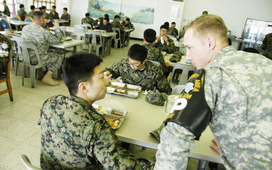 Pfc. Joshua Dixon, 23, of Brainerd, Minn., catches up with a South Korean friend during lunch at Camp Bonifas, South Korea, in April 2015.