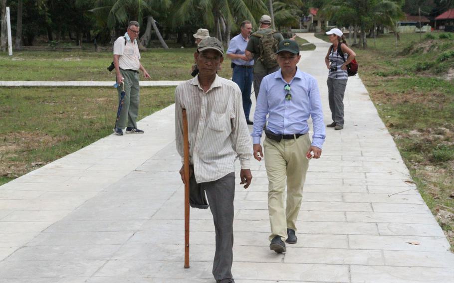 Em Son, left, former Khmer Rouge commander of Koh Tang during the May 15, 1975, Vietnam War battle, arrives at the dedication of plaques to honor the fallen from both sides during a May 12, 2015, ceremony commemorating the 40th anniversary of the battle.