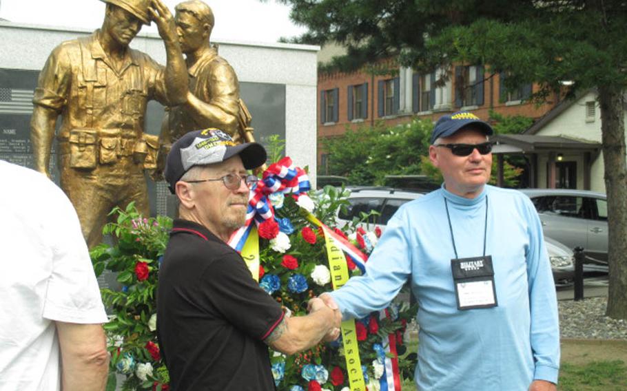 Bob Haynes, left, and John Batty-Sylvan, right, both former 2nd Infantry Division soldiers who served in South Korea during the 1960s, pose Monday, June 29, 2015, in front of a memorial at U.S. Army Garrison Yongsan. The memorial honors U.S. and South Korean troops killed in combat since the end of the Korean War. Haynes and Batty-Sylvan are part of a veterans group that traveled to South Korea to take part in 50th anniversary celebrations this week of 2ID's presence on the peninsula.