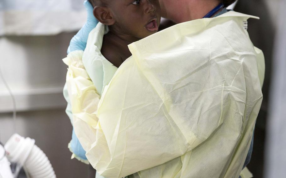 Cmdr. Marion Henry, a pediatric surgeon from San Diego, calms an infant in the casualty reception area of the Military Sealift Command hospital ship USNS Mercy, June 30, 2015. Mercy sent an MH-60S Sea Hawk helicopter on a critical care patient transport mission to retrieve six injured people, including an 18-month-old infant, from Han Island off the coast of Carteret Island in Papua new Guinea. Mercy was in Papua New Guinea for its second mission port of Pacific Partnership 2015.