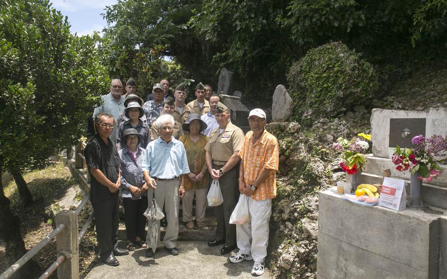 In this file photo from June 23, 2014, Marines and community members pose next to a memorial for Col. Kermit Shelly on Hamahiga Island, Okinawa, Japan. Infrastructure, including a reservoir that's still in use today, that Shelly and his Marines brought to Hamahiga in the 1960s was so appreciated by community members that a memorial was constructed for him following his death in 1968.
