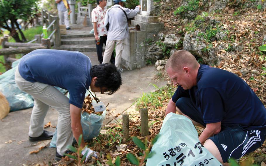 In this file photo from June 22, 2011, volunteers clean around Col. Kermit Shelly's memorial site on Hamahiga Island, Okinawa, Japan. Shelly, commanding officer of 3rd Force Service Regiment, known today as 3rd Force Service Support Group, helped bring much-needed infrastructure to the island in the late 1960s.