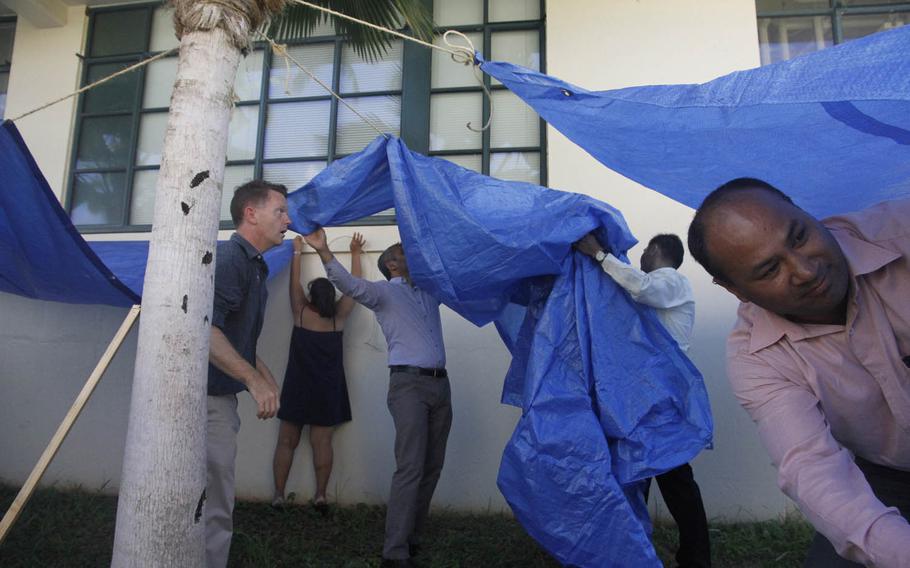 Students attending the Health Emergencies in Large Populations course Aug. 19, 2015, on Ford Island, Hawaii, scurry to build four makeshift shelters in 20 minutes as part of a two-week curriculum for disaster-response personnel.