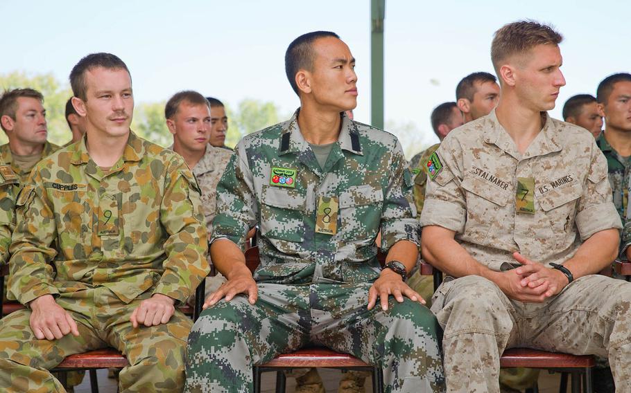 Australian Army soldier Pvt. Caleb Cupples, from left, People's Liberation Army Cpl. Chao Luo and U.S. Marine Cpl. Tyler Stalnaker with 1st Battalion, 4th Marine Regiment, Marine Rotational Force-Darwin, listen as a Larrakia Aboriginal Nation elder speaks during the Exercise Kowari 15 opening ceremony at Larrakeyah Barracks in Darwin, Northern Territory, Aug. 29, 2015.
