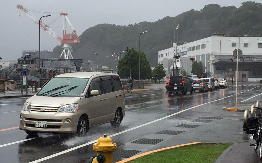 Vehicles make their way along slick roads at Yokosuka Naval Base, Japan, Wednesday, Sept. 9, 2015. U.S. bases experienced heavy rains due to Tropical Storm Etau, which caused floods and mudslides elsewhere in Japan.