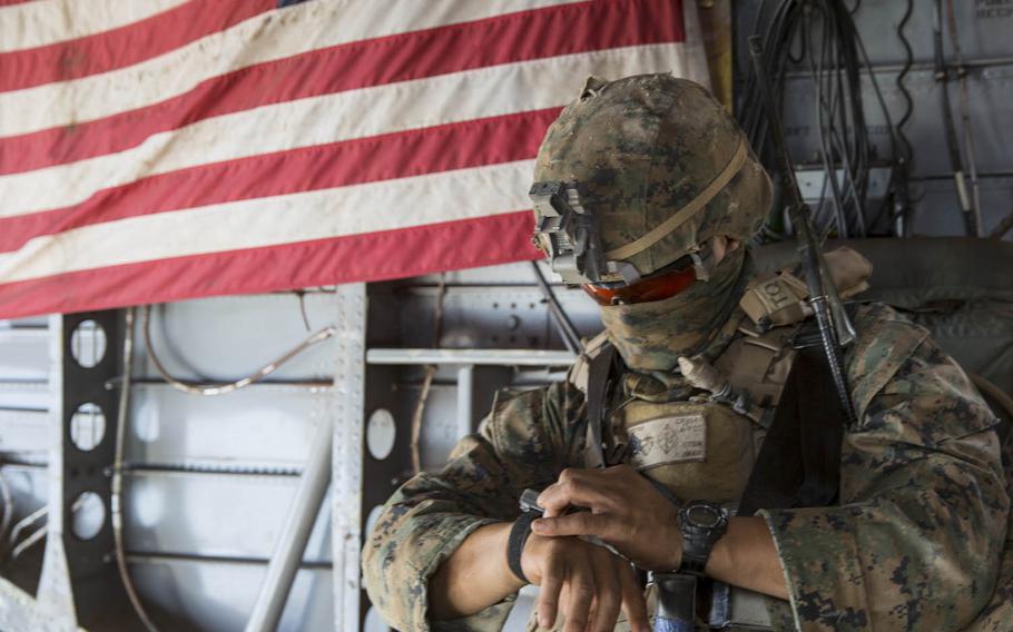 U.S. Marine Corps Sgt. Marcus Reyna, a squad leader with Company C, 1st Battalion, 4th Marine Regiment, Marine Rotational Force-Darwin, checks the time before descent aboard a CH-53E Super Stallion helicopter during an air assault course Aug. 24, 2015, at Mount Bundey Training Area, Northern Territory, Australia.