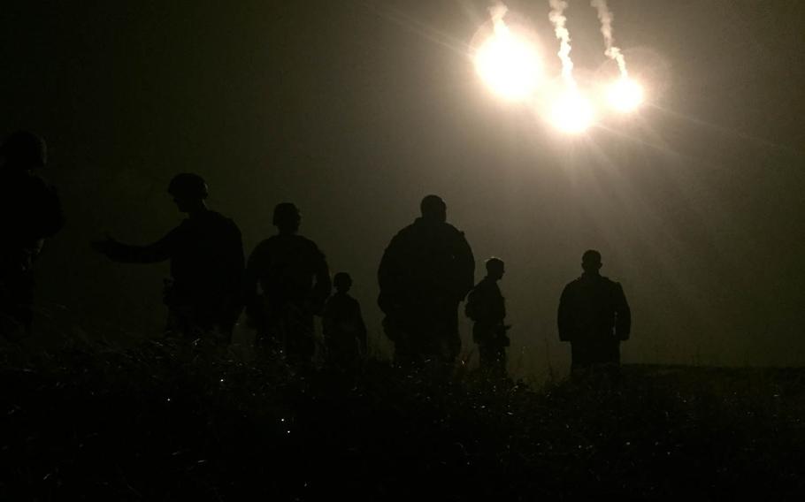 Flares from a C-130 Hercules transportation aircraft illuminate the landing zone for an incoming CH-53 Super Stallion helicopter during a fire-support coordination exercise that kicked off Blue Chromite 2016 on Okinawa, Japan.