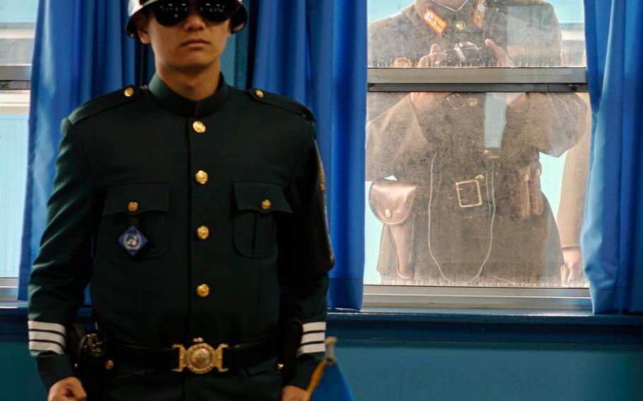 A North Korean soldier looks over the shoulder of a South Korean soldier Monday, Nov. 2, 2015, inside the United Nations Command Military Armistice Commission Conference Building at the Joint Security Area of the Demilitarized Zone between North and South Korea. The conference building is used by United Nations representatives and South and North Korean diplomats during negotiations.