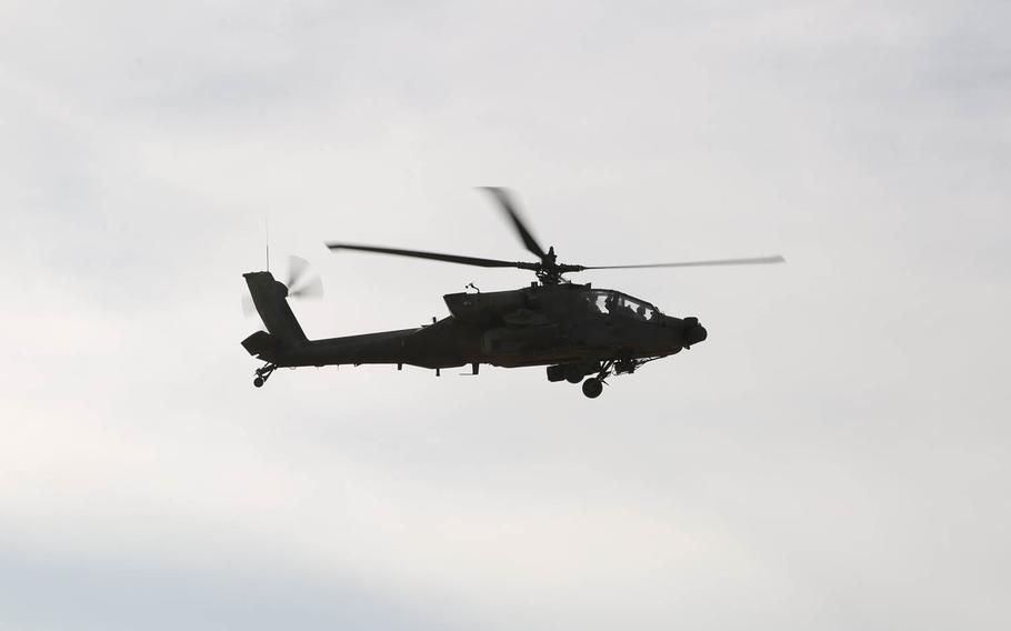 An AH-64 Apache helicopter flies over the National Training Center at Fort Irwin, Calif., Nov. 11, 2014. An Apache that crashed in South Korea Monday, Nov. 23, 2015, killing both pilots may have collided with a power pylon or high-tension wires, according to South Korea media.