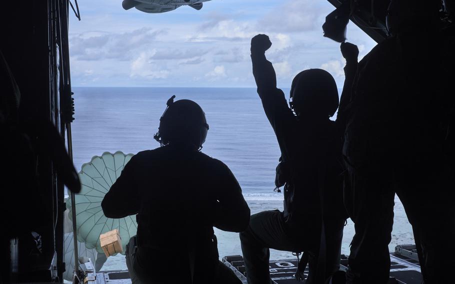 Airmen from Yokota Air Base's 374th Airlift Wing, along with members of the Japan Air Self-Defense Force, send two bundles of humanitarian aid to villagers living on the atoll of Namoluk in the Federated States of Micronesia on Wednesday, Dec. 9, 2015. The airdrop is part of Operation Christmas Drop, an annual humanitarian mission that provides aid to people in remote parts of the Northern Marianas Islands, Federated States of Micronesia and Republic of Palau.