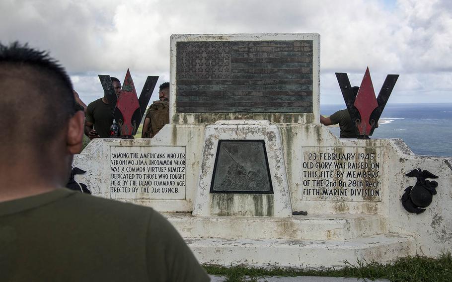 A Marine from Marine Corps Air Station Iwakuni, Japan, looks at the raising of colors memorial atop Mount Suribachi on Iwo Jima, Nov. 7, 2017.