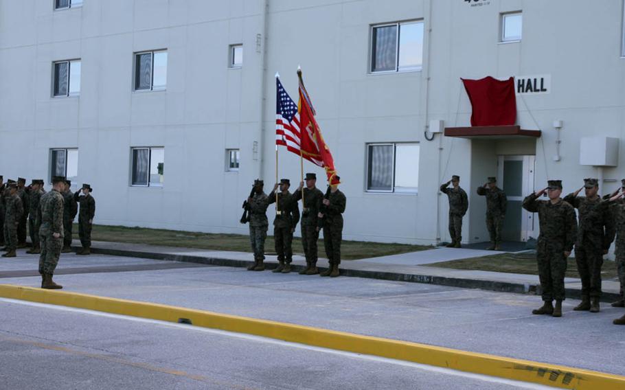 Marines stand at attention during a ceremony to name a new barracks building at Camp Courtney, Okinawa, for Navy Cross recipient Marine Staff Sgt. Claude Dorris, Friday, Dec. 22, 2017.