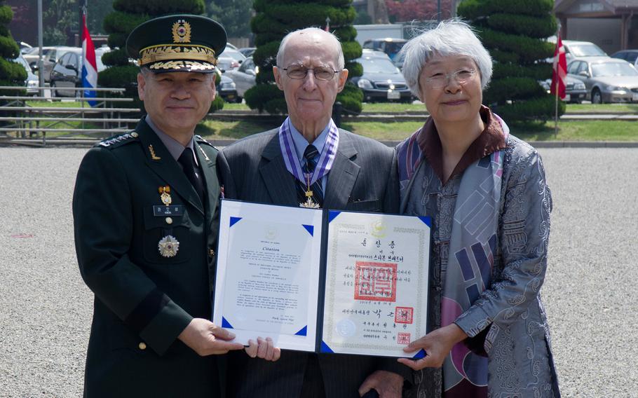 South Korean Gen. Kwon Oh-Sung presents Stephen Bradner, standing next to his wife, Shin-ja, the Korean Order of National Security Merit, Gukseon Medal at Yongsan Garrison, South Korea, May 15, 2013.