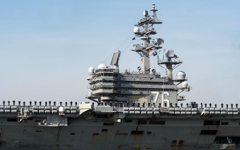 Sailors man the rails as the aircraft carrier USS Ronald Reagan arrives at Yokosuka Naval Base, Japan, Dec. 4, 2017.