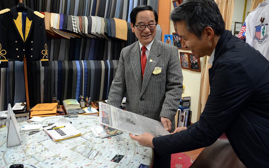 Chang Chin-kuk, left, owner of a tailoring company inside Dragon Hill Lodge at Yongsan Garrison, South Korea, speaks in December 2017 with Daniel Oh, co-founder of the Yongsan Legacy project.