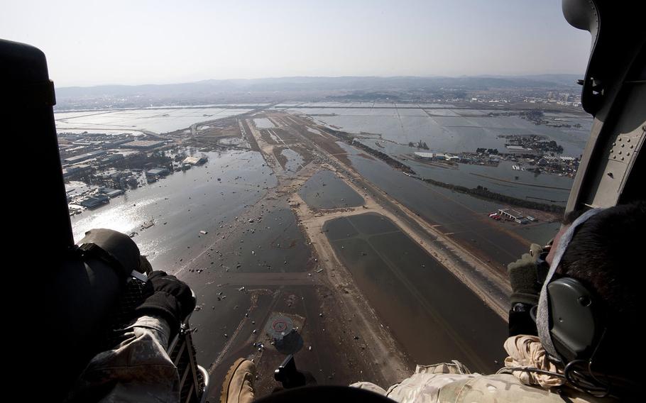 A joint-service survey team flies over the damaged Sendai International Airport on March 13, 2011, two days after a massive earthquake and tsunami ravaged Japan's northeastern coast.