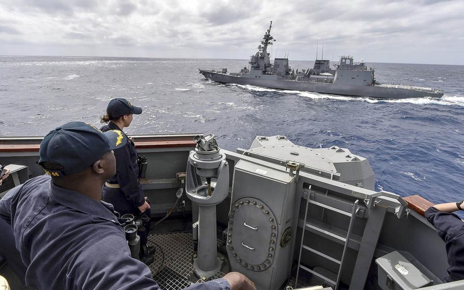 The guided-missile destroyer USS Benfold, foreground, sails alongside the Japanese destroyer JS Fuyuzuki during a close-quarters maneuvering drill last month in the Philippine Sea. Both ships are taking part in MultiSail 2018, which is underway near Guam.