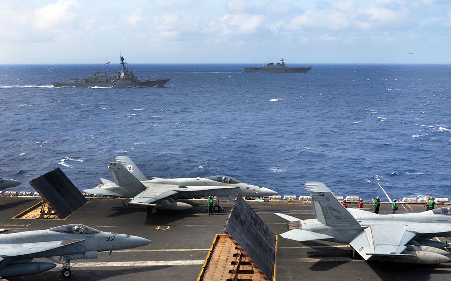 Ships steam alongside the aircraft carrier USS Carl Vinson last month in the Philippine Sea.