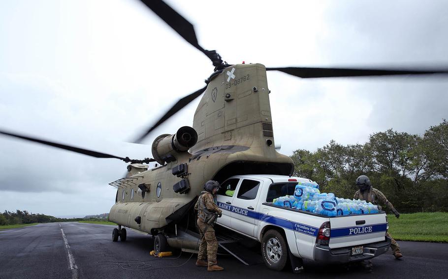 Soldiers from the 25th Combat Aviation Brigade, 25th Infantry Division load a law enforcement vehicle loaded with water onto a CH-47 Chinook, Tuesday, April 17, 2018, to assist in disaster-relief operations on the Hawaiian island of Kauai after severe rains, flooding and mudslides stranded hundreds of residents and tourists.