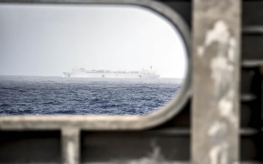 The USNS Brunswick sails past the hospital ship USNS Mercy, background, en route to its first Pacific Partnership mission stop, March 19, 2018.