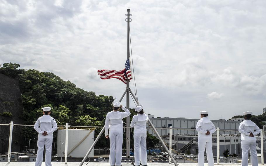 Sailors lower the flag to shift to underway colors as the USS Ronald Reagan departs Yokosuka Naval Base, Japan, Tuesday, May 29, 2018.