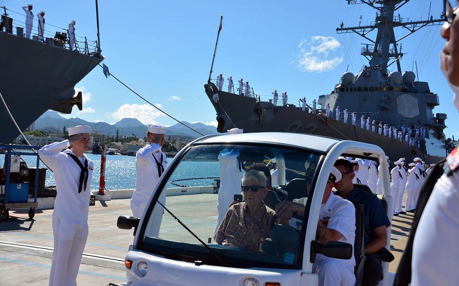 Pearl Harbor attack survivor Ray Emory is driven through a Navy honor cordon, June 19, 2018, at Pier B-21, Joint Base Pearl Harbor-Hickam, as other sailors man the rails of the USS Chung-Hoon in the background.