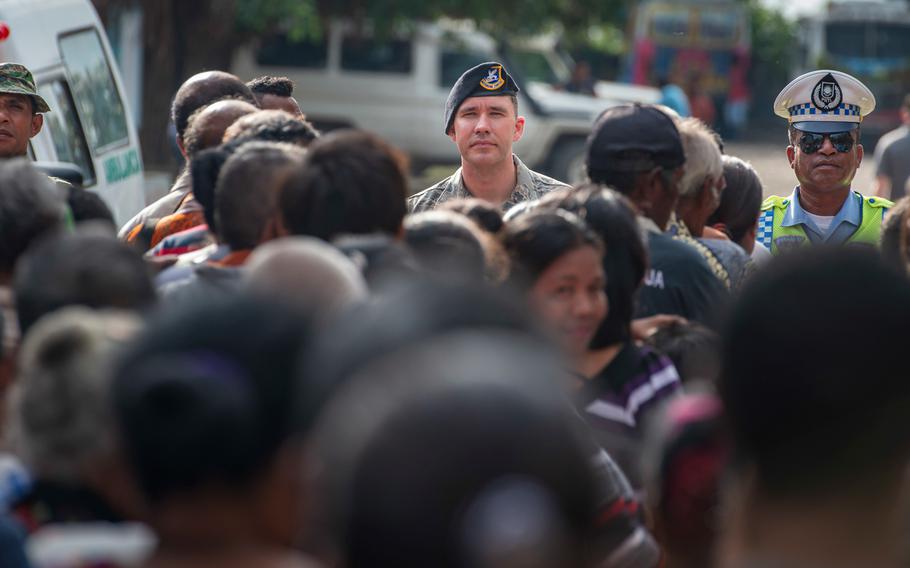 U.S. Air Force Master Sgt. Justin Haggerty, center, the 18th Security Forces Squadron flight chief from Kadena Air Base, Japan, and Julio Mayo daSilva, right, a traffic officer with the Suai Police, organize the crowd forming on the first day of the health services outreach site during Pacific Angel 2018 at the Negri Saran Kote Secondary School in Covalima Province, Timor-Leste, June 11, 2018.