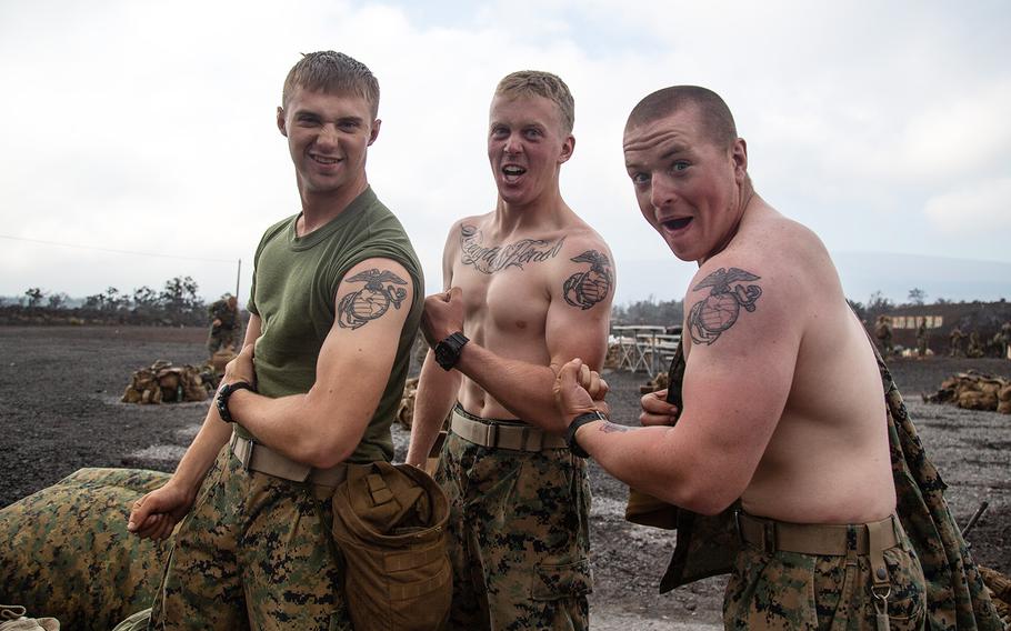 Left to right: Pfc. Larry Howdyshell, of Logan, Ohio; Lance Cpl. Brendan Clark, 19, of Lenexa, Kan.; and Pfc. Travis Stiles, 20, of  Queensbury, N.Y., show off their tattoos at Pohakuloa Training Area, Hawaii, Wednesday, July 18, 2018. 
