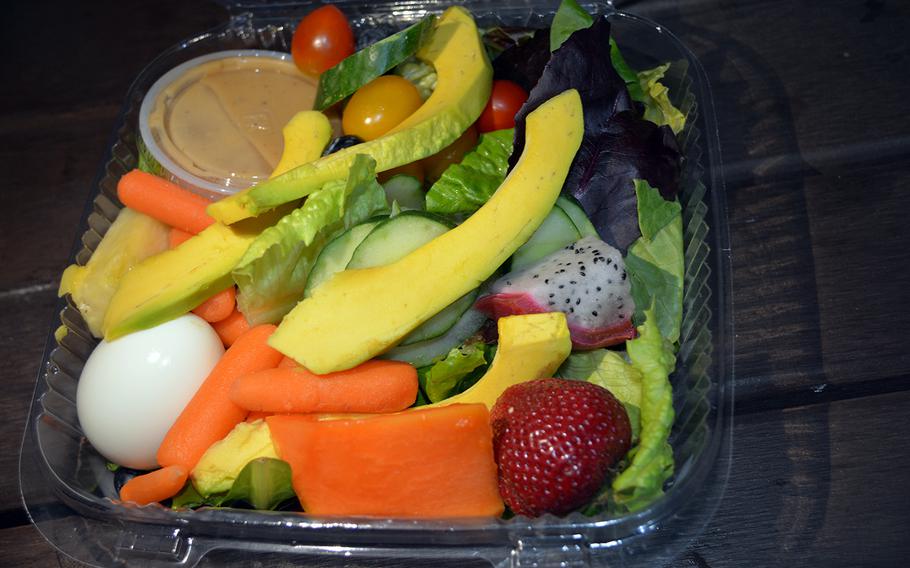 The Gourmet Sticky Rice kiosk in Honolulu piles its fruit salad high with large slices of papaya, avocado, dragon fruit and cucumber, along with strawberries, cherry tomatoes, and an egg atop a bed of romaine lettuce.