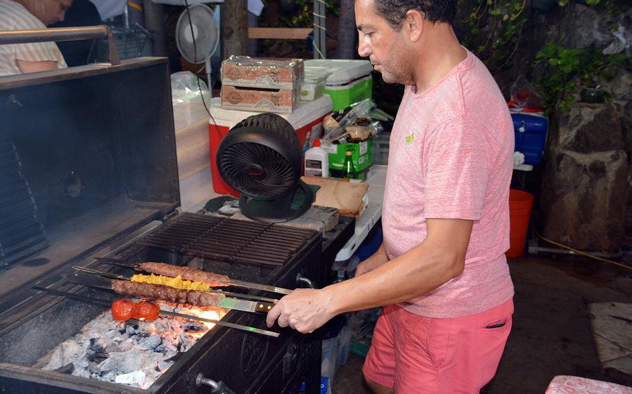 Kabab Nooni’s Shahim Gholami tends to meat and tomato skewers over a bed of charcoal at a new food truck haven in Honolulu.