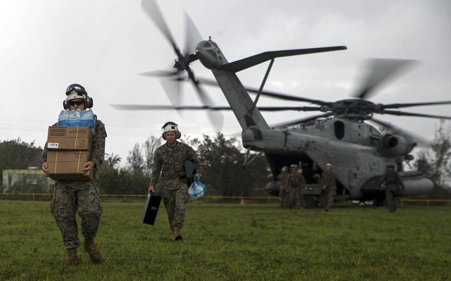 Marines carry supplies from a CH-53E Super Stallion during typhoon relief efforts in Rota, Northern Mariana Islands, Sept. 11, 2018.