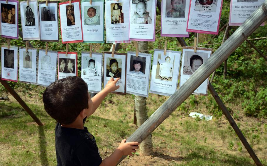 Garrett Nissen points to a baby picture of his father, Christian Nissen, who was adopted from South Korea, Sept. 12, 2018. The photos were part of a ceremony for a memorial park in Paju, South Korea.