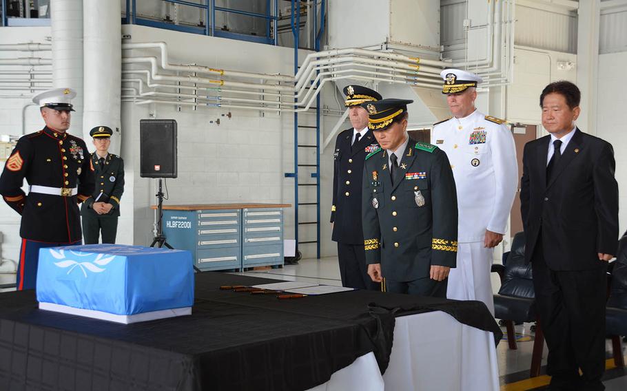 Col. Hak Ki Lee, commander of South Korea's KIA Recovery and Identification agency, bows before a box holding the remains of an unidentified South Korean soldier during a repatriation ceremony at Joint Base Pearl Harbor-Hickam, Hawaii, Thursday, Sept. 27, 2018. Standing behind him, from left, are United Nations Command Chief of Staff Maj. Gen. Mark Gillette; Rear Adm. Jon Kreitz, deputy director of the Defense POW/MIA Accounting Agency; and Choo Suk Suh, South Korea's vice minister of national defense.