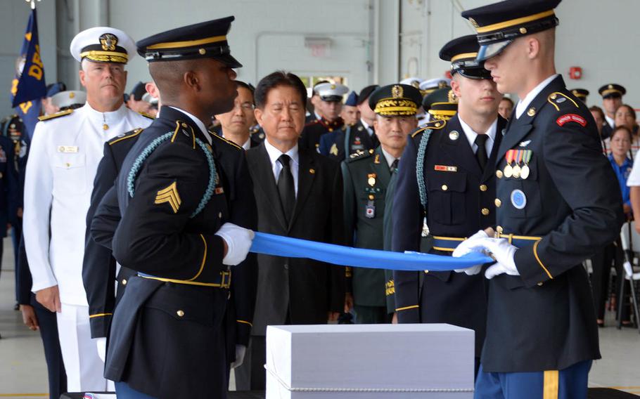 South Korean and American officials watch as a United Nations flag is removed from a box of remains and folded during a repatriation ceremony at Joint Base Pearl Harbor-Hickam, Hawaii, Thursday, Sept. 27, 2018.