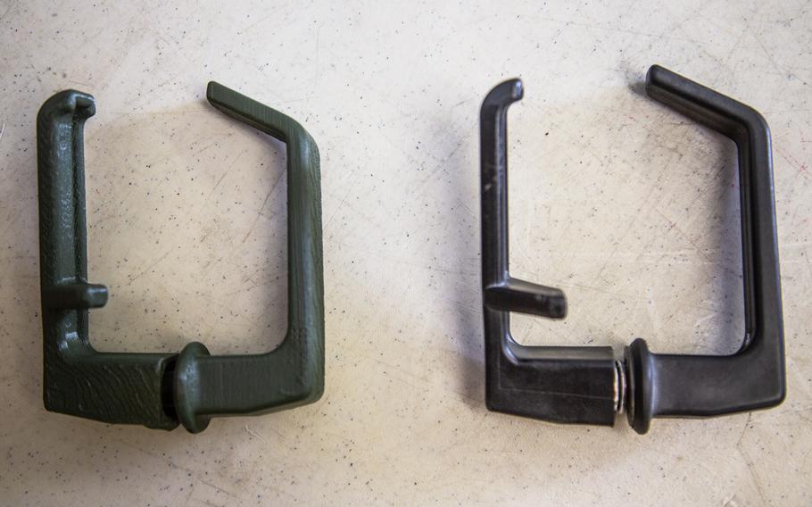 A 3-D printed Humvee door handle, left, sits next to an original model at Camp Humphreys, South Korea, Monday, Oct. 29, 2018.