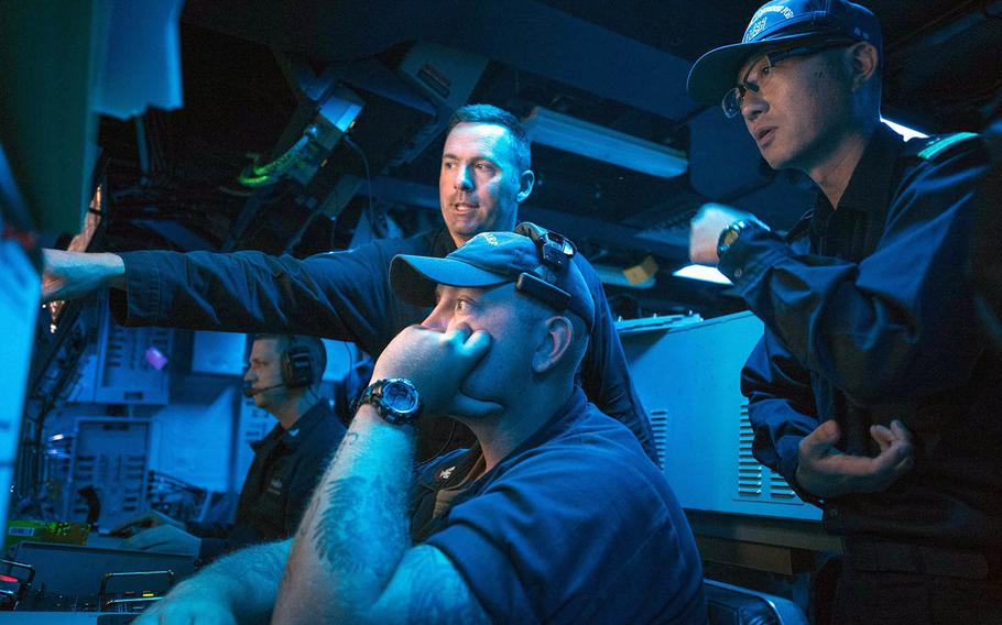 Lt. Cmdr. William Russell and Petty Officer 2nd Class Joseph Larsen of the mine-countermeasures ship USS Chief demonstrate the ship's sonar capabilities to Lt. Cmdr. Akihiko Morita of the Japan Maritime Self-Defense Force during July drills off Aomori prefecture.