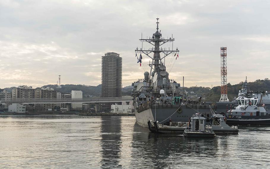 The guided-missile destroyer USS Barry is pulled toward a pier after departing dry dock at Yokosuka Naval Base, Japan, Monday, Dec. 3, 2018.