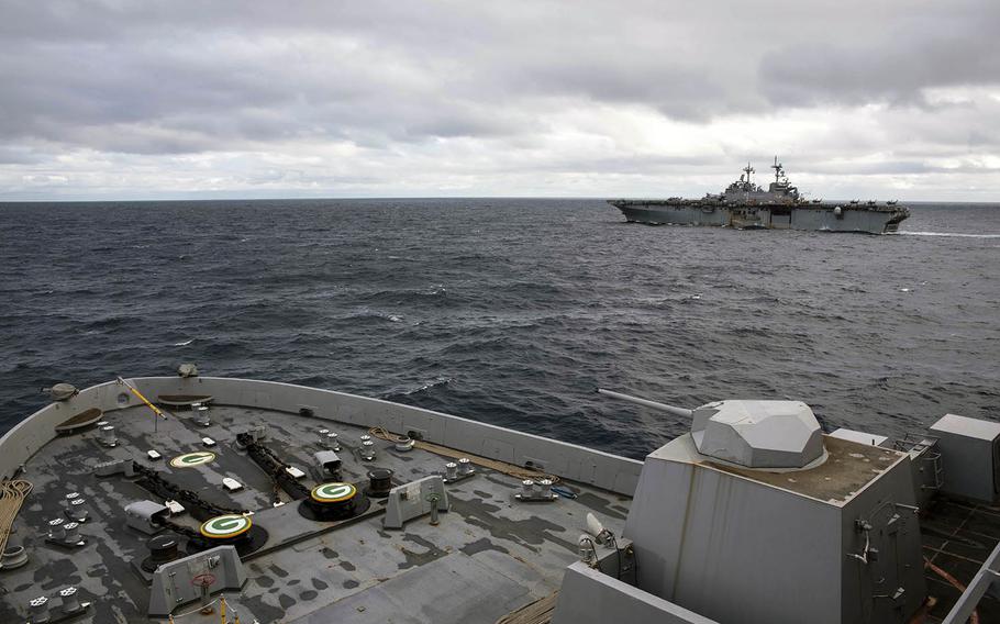 The amphibious assault ship USS Wasp, background, and the amphibious transport dock ship USS Green Bay steam in the East China Sea on Friday, Jan. 12, 2019.