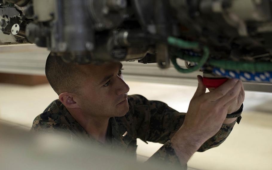 First Lt. Simon Miller of Marine Aviation Logistics Squadron 12 at Marine Corps Air Station Iwakuni, Japan, demonstrates the installation of drain plugs that are part of an engine ship kit he designed and built using a 3D printer, Nov. 29, 2018.