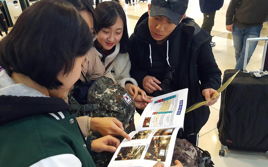 South Korean ROTC cadets look at a pamphlet about their itinerary before leaving Seoul to participate in a monthlong leadership development course at Texas A&M University.