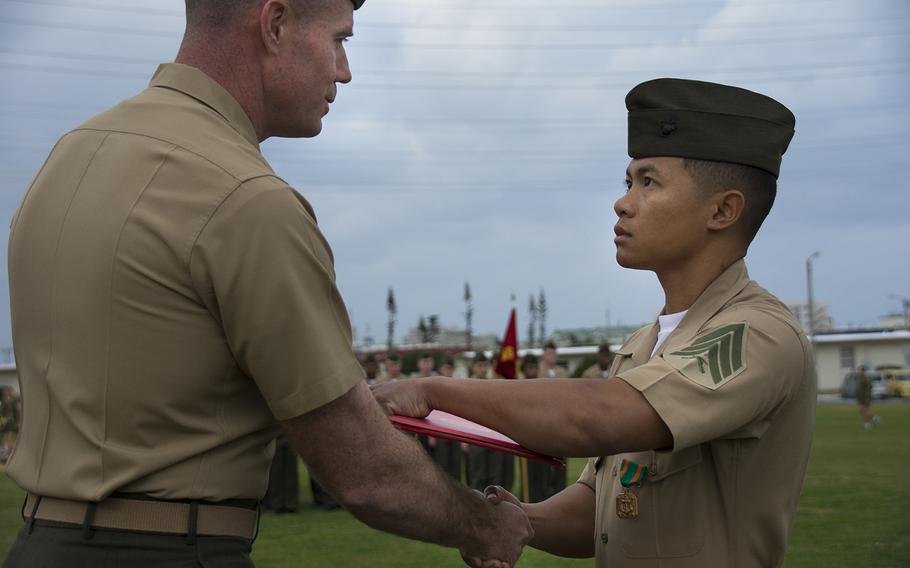 Marine Sgt. David Nguyen Lam, right, is awarded the Navy and Marine Corps Achievement Medal at Camp Foster, Okinawa, Friday, Feb. 1, 2018. Lam gave first aid to an airman after a New Year's Eve motorcycle accident.